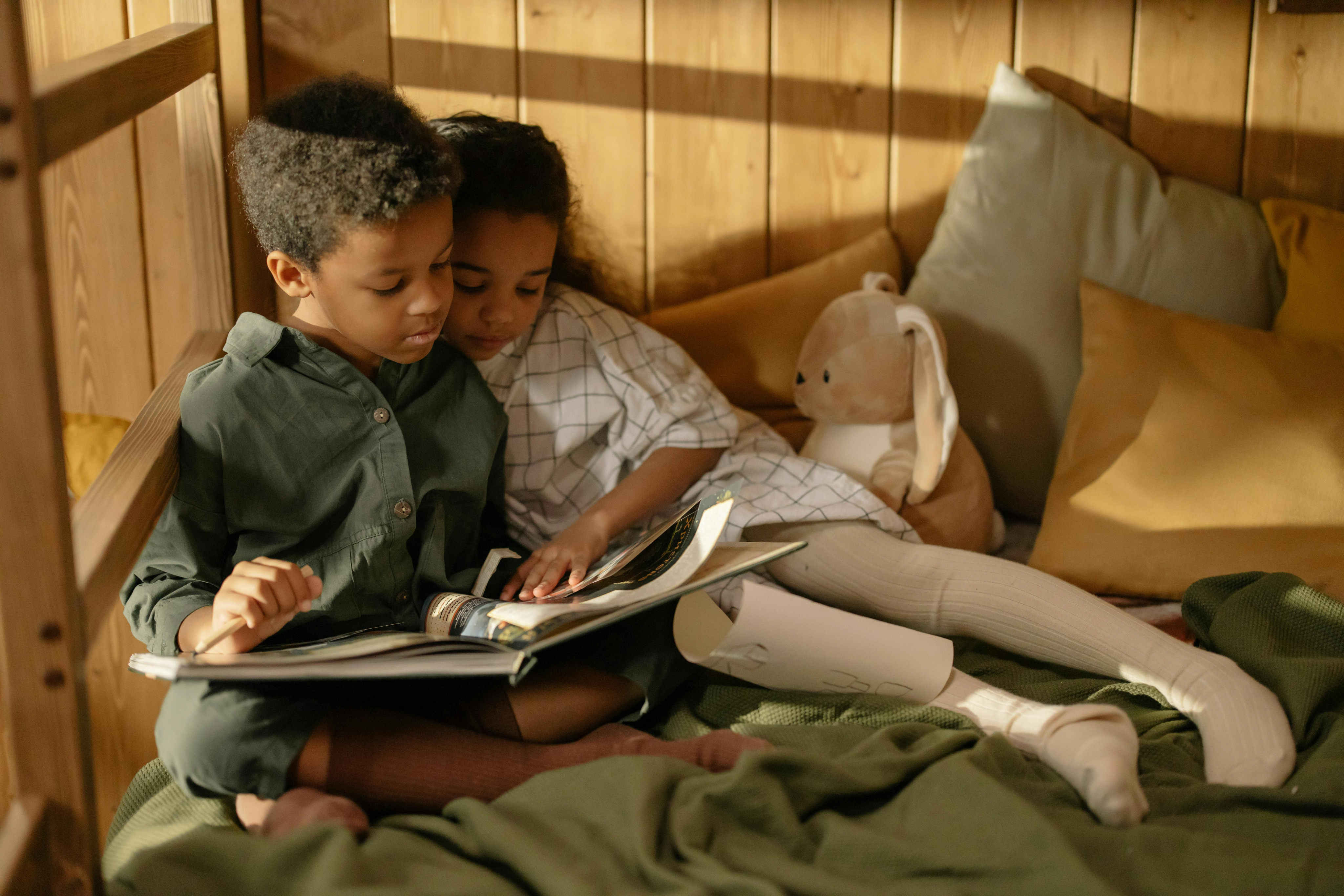 two kids sitting and reading a book